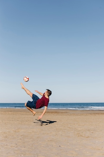 guy-playing-football-beach_23-2147803101.jpg