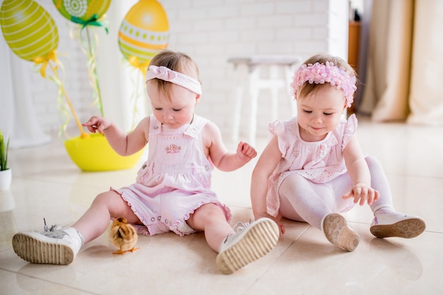 two-little-girls-pink-dresses-play-floor-studio-with-easter-decor_8353-7463.jpg