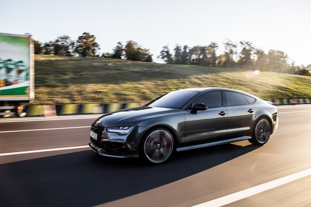 grey-luxury-sedan-car-driving-highway_114579-4024.jpg