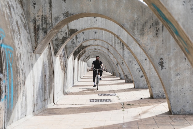 man-black-clothing-riding-bicycle-archway_23-2148176526.jpg